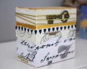 Collage pequeño y elegante, en blanco y negro, dorado, con motivos, letras, cinta dorada y llave, minimalista, de Beate Frieling.