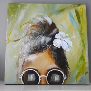 Pu&ograve; includere: Un dipinto di una donna con i capelli raccolti in uno chignon, che indossa occhiali rotondi e un fiore bianco dietro l'orecchio. Lo sfondo &egrave; un design astratto verde e blu.