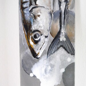 Könnte beinhalten: Vertikale Leinwandkunst mit einem Gemälde von zwei Fischen in Grau-, Weiß- und Schwarztönen. Die Fische sind in einem realistischen Stil dargestellt, mit detaillierten Schuppen und Flossen. Der Hintergrund ist eine Mischung aus grauen und weißen Pinselstrichen.