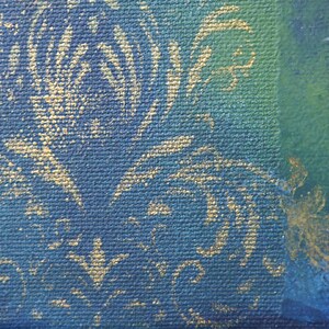 K&ouml;nnte beinhalten: Nahaufnahme eines abstrakten Gem&auml;ldes mit strukturierter Leinwand. Das Kunstwerk zeigt einen tiefblauen Hintergrund mit goldenen floralen Mustern. Ein Abschnitt in Gr&uuml;n und Blau ist sichtbar, zusammen mit einer Figur mit wei&szlig;en und goldenen Details.