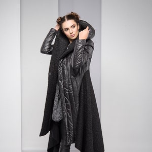 Stylish, fun and warm, this asymmetric jacket with padded detailing will get you compliments all the time! Featuring an oversized hood, button down closure and a silhouette that emphasizes the waist, this coat is both feminine and edgy.