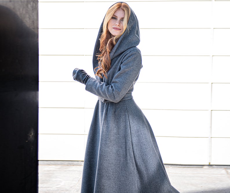 This elongated coat is the perfect mix between boho and elegant. It has a beautiful silhouette with a tie waist and rich skirt, while the slouchy hood, hidden buttons and side pockets lend functionality.