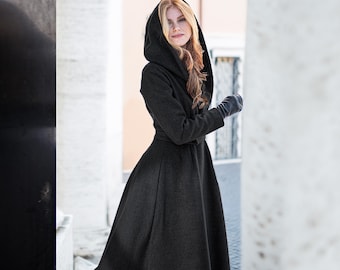 May include: A long, black hooded coat with a belt. The coat has a flared skirt and is made of a soft, warm fabric.