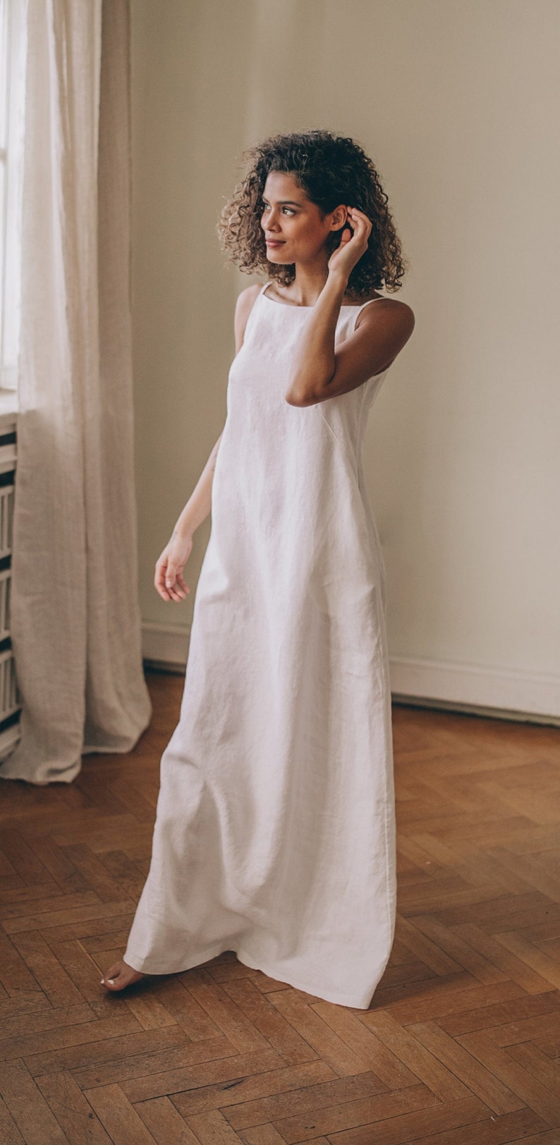 Designed entirely in natural linen, this floor length sleeveless dress is a seasonal essential. А minimalist piece that has elongated silhouette, hem pockets, boat neckline and a tie knot closure at the back.