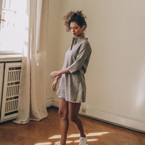 Sense the summer ease in this essential linen tunic top. It features a kaftan cut, a split shirt neckline, three-quarter sleeves and side slits.
