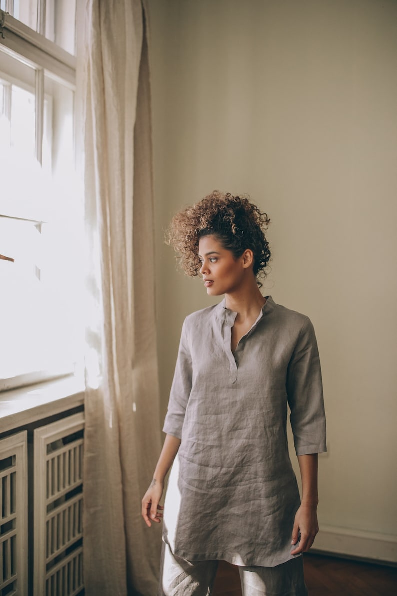Sense the summer ease in this essential linen tunic top. It features a kaftan cut, a split shirt neckline, three-quarter sleeves and side slits.