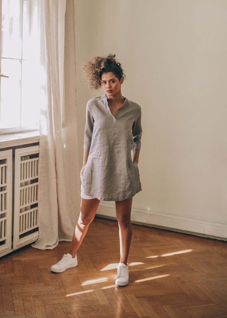 Sense the summer ease in this essential linen tunic top. It features a kaftan cut, a split shirt neckline, three-quarter sleeves and side slits.