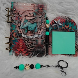 May include: A spiral-bound notebook with a western-themed graphic of a person in a hat and the text THE HELL I WON'T, a matching beaded pen, a sticky note holder with a star design, and a beaded keychain with turquoise, black, and leopard print beads.