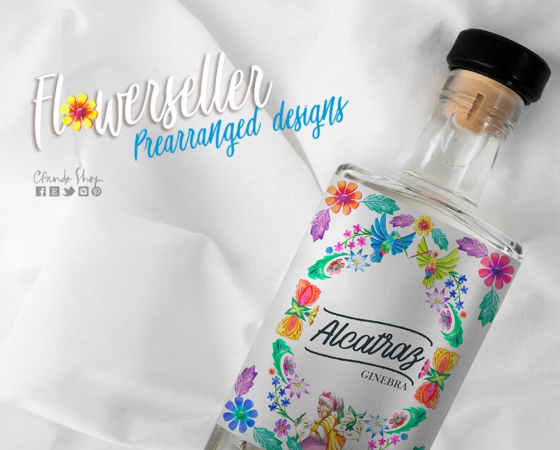 May include: A clear glass bottle with a black cap and a colorful floral label. The label features a wreath of flowers, birds, and the text "Alcatraz Ginebra".