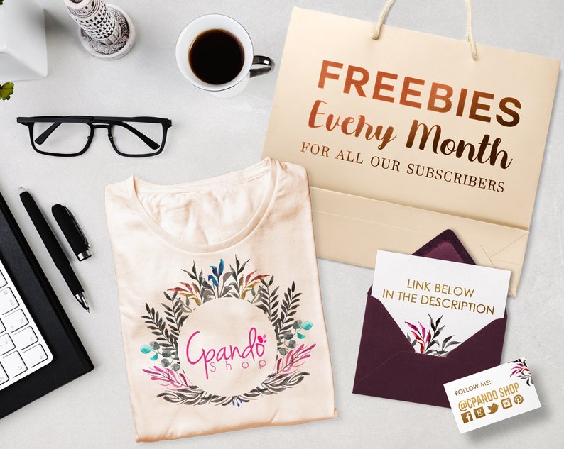 May include: A beige t-shirt with a floral wreath design and the text "Gpando Shop" in a circle. A brown paper bag with the text "FREEBIES Every Month FOR ALL OUR SUBSCRIBERS". A burgundy envelope with a white card inside that says "LINK BELOW IN THE DESCRIPTION". A business card with the text "FOLLOW ME @CPANDO SHOP" and social media icons.