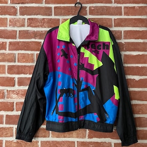 Op de afbeelding: Een vintage jack met ritssluiting in een levendig kleurenschema. De jas heeft een zwarte basis met panelen in blauw, paars en neon groen. Het ontwerp bevat grafische elementen en de tekst "Tech MTB". De jas heeft een mesh voering en twee voorzakken.