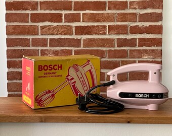 Batedeira manual vintage Bosch HM/Q1, rosa, década de 1950/60, com embalagem original.