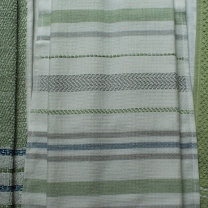 May include: Three kitchen towels with a striped pattern in shades of green, gray, and white.