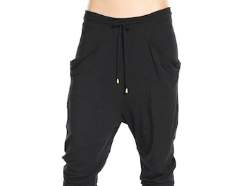 May include: Black, loose-fitting pants with a drawstring waist and side pockets. The pants are made of a soft, comfortable fabric and have a relaxed fit.