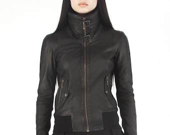May include: A black leather jacket with a high collar and zipper closure. The jacket has a fitted silhouette and a slightly cropped length.