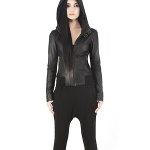 May include: A black leather jacket with a hood and zipper closure. The jacket has a fitted silhouette and features a buckle detail on the front.