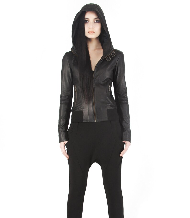 May include: A black leather jacket with a hood and zipper closure. The jacket has a fitted silhouette and features a buckle detail on the front.