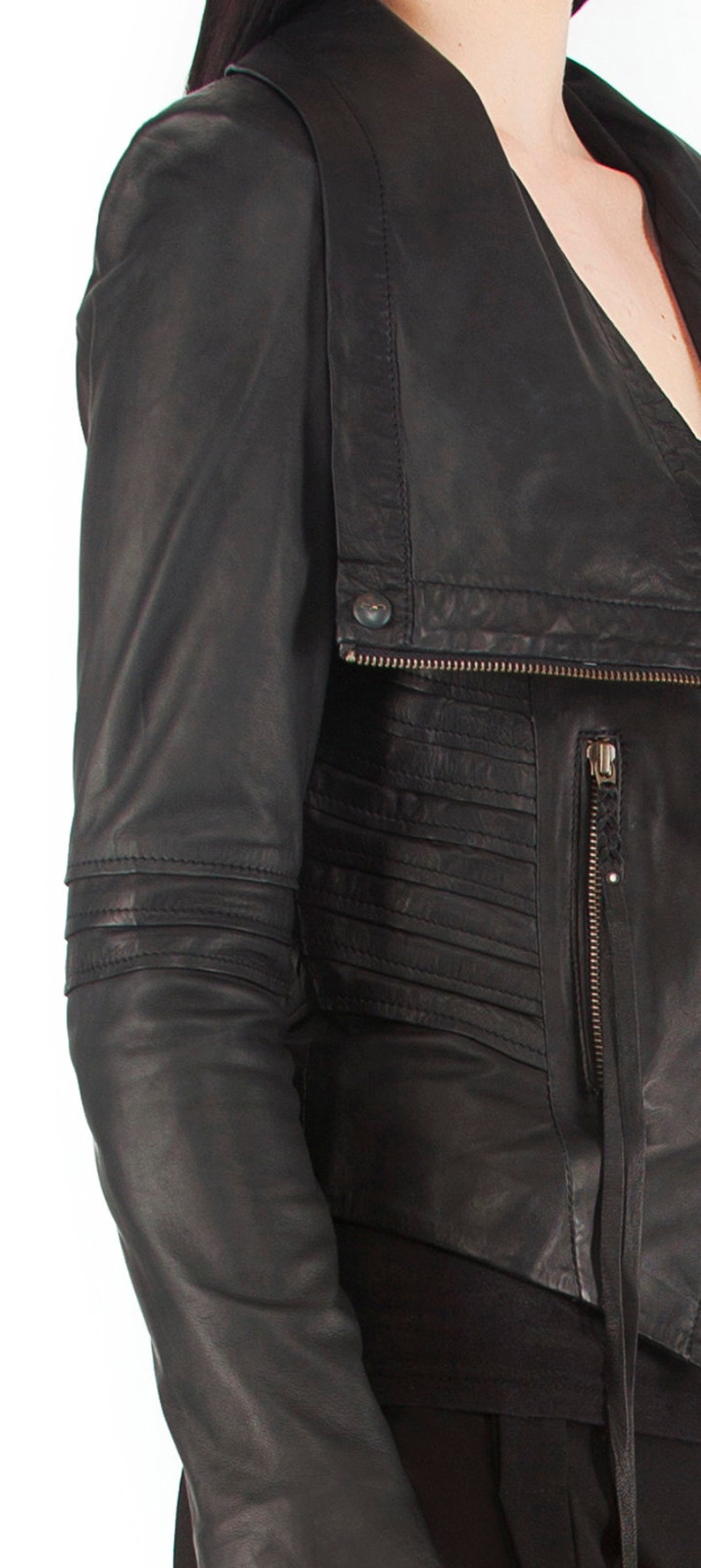 Puede incluir: Chaqueta de cuero negra con un dise&ntilde;o asim&eacute;trico. Cuenta con cierre de cremallera, detalle de bot&oacute;n y detalles plisados. Las mangas tienen un ajuste entallado. La chaqueta es de cuero.