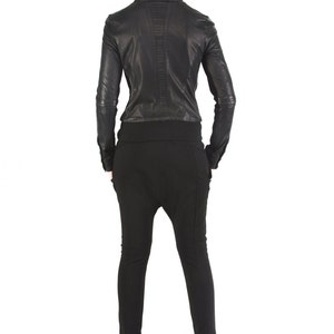May include: A black leather jacket with a hood and zipper closure. The jacket has a quilted design on the back and is worn over black pants.