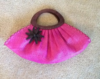 Fushia woven handbag with wood handles hand stitched around purse