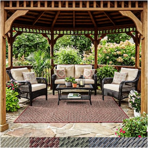 May include: Outdoor patio set under a wooden gazebo. The set includes a loveseat, two armchairs, and a coffee table with decorative pillows. A red and brown rug sits on the stone patio, surrounded by plants and flowers.