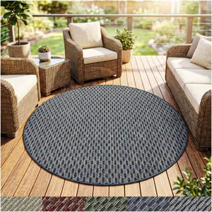 May include: A round outdoor rug with a geometric pattern in shades of blue, beige, and gray. The rug has a dark blue border and is placed on a wooden deck. The rug is designed for outdoor use and adds a decorative element to the patio.