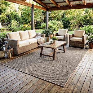 May include: Outdoor patio furniture set with a woven wicker sofa, two armchairs, and a wooden coffee table. A large rectangular rug with a brown and beige pattern covers the deck. Potted plants and lanterns complete the outdoor living space.