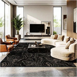 May include: A modern living room featuring a large black rug with a swirling pattern, a curved beige sofa, and two brown leather armchairs. A black marble coffee table sits in the center, with a large flat-screen TV on the wall.