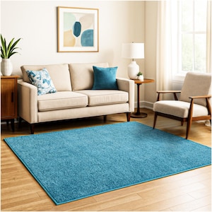 May include: A rectangular area rug featuring a solid, vibrant turquoise blue color with a textured, plush pile surface. The rug is positioned flat on a light-toned wooden floor, providing a bold, saturated color contrast to the surrounding furniture.