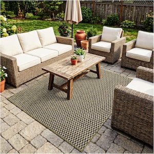 May include: Outdoor patio furniture set with a woven wicker design. The set includes a three-seat sofa, two armchairs, and a wooden coffee table. A patterned rug and potted plants complete the outdoor living space.
