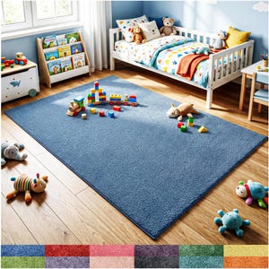 May include: A rectangular blue area rug with a soft, textured pile surface. The rug is positioned on a wooden floor in a room with a child's bed, a wooden bookshelf, and various plush toys scattered across the blue surface.