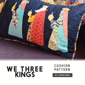 Könnte beinhalten: Ein marineblaues Kissen mit Patchwork-Design, das drei Könige zeigt, die Geschenke halten. Das Kissen hat einen weißen Hintergrund mit einem dezenten Glitzereffekt und einen gelben Rand. Der Text "We Three Kings" ist unter dem Kissen gedruckt.