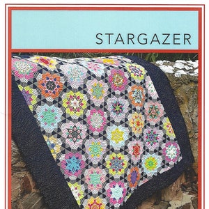 Puede incluir: Un patrón de colcha colorido llamado "Stargazer" de Lilabelle Lane Creations, diseñado por Sharon Burgess. La colcha está hecha con piezas de papel inglesas y presenta una variedad de colores brillantes y formas geométricas.