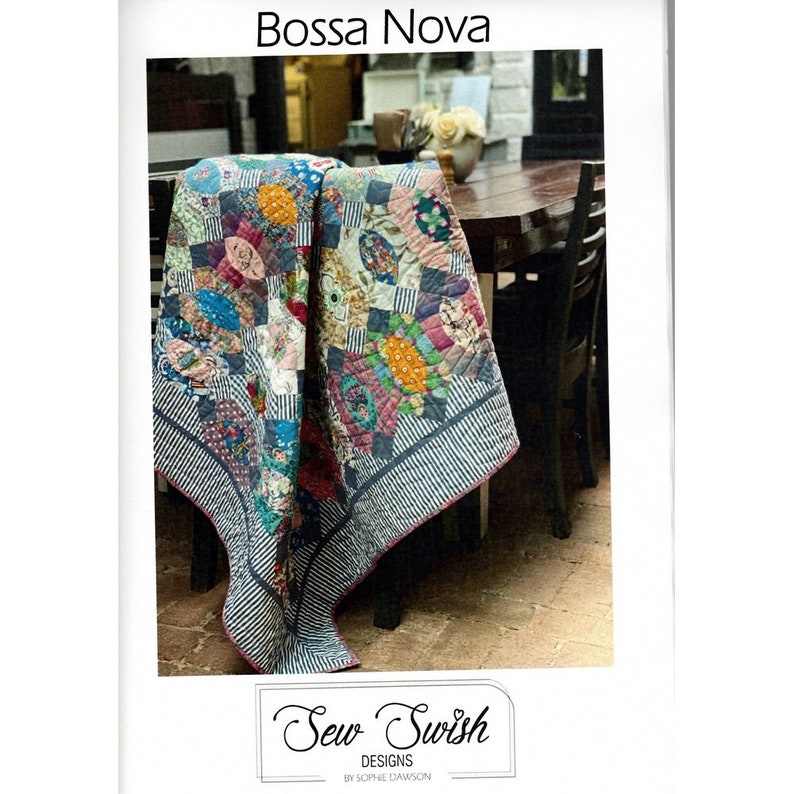 May include: A colorful quilt pattern called "Bossa Nova" by Sew Swish Designs. The quilt is made with a variety of fabrics in shades of pink, blue, green, yellow, and red. The quilt is folded and draped over a chair.