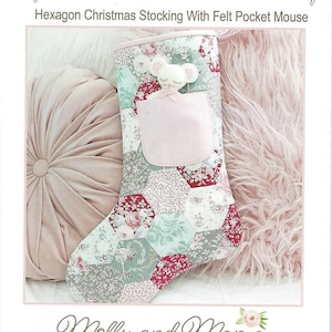 May include: A Christmas stocking with a patchwork design of floral and geometric patterns. The stocking features a felt pocket and a felt mouse applique. The text "Night Before Christmas Stocking" is at the top.