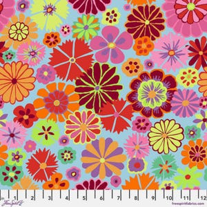 May include: A colourful floral fabric with a light blue backdrop. The design showcases an assortment of flowers in pink, orange, red, yellow, and purple. The fabric has a ruler along the bottom edge, with measurements in inches.