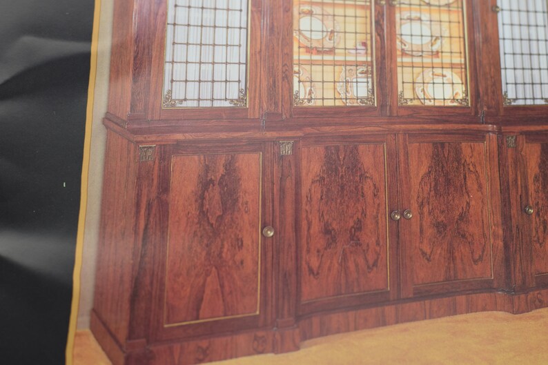 May include: A wooden cabinet with glass doors and drawers. The cabinet has a dark wood finish and brass accents. The glass doors are decorated with a grid pattern.