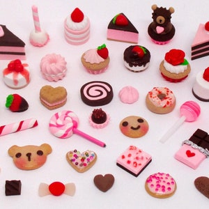 May include: A collection of miniature, handcrafted sweets and treats, including cakes, cookies, macarons, and candies. The assortment features various colors and designs, such as pink, brown, and white, with heart and bear shapes. The image includes the text "MollysMiniStuff".