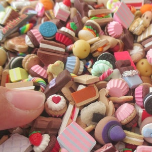 May include: A large collection of miniature food items, including cakes, cookies, candies, and other treats. The items are made of polymer clay and are very detailed. The image shows a variety of colors and textures.