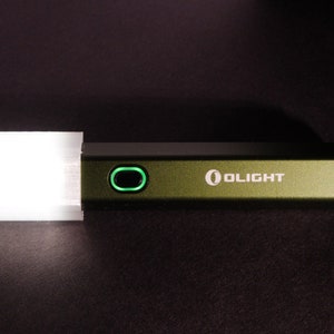 May include: A green flashlight with a white diffuser on the end. The flashlight has a green power button and the word "OLIGHT" printed on the side.