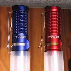 May include: Two small flashlights, one blue and one red, with a textured metal body and a clear plastic diffuser. The flashlights are labeled "Baton 4" and "Baton 3" with model numbers.
