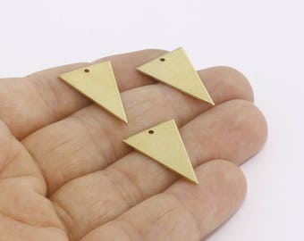 Puede incluir: Tres pequeños dijes triangulares dorados con un agujero en la parte superior para hacer joyas. Los dijes se sostienen en una mano sobre un fondo blanco. Estos dijes geométricos son ideales para aretes, collares u otros proyectos de artesanía.