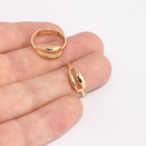 Può includere: Anello e ciondolo regolabili color oro con design a conchiglia. L'anello ha una fascia regolabile per adattarsi a diverse misure di dita. Il ciondolo è a forma di piccola conchiglia cava.