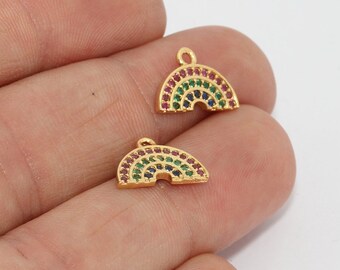 May include: Two gold-coloured rainbow charms with colourful gemstones. Each charm features a rainbow design with red, green, and blue stones. The charms have a small loop at the top for attaching to jewellery.