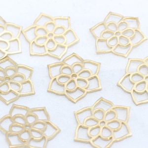 Peut inclure: Charm en métal doré en forme de fleur. Chaque breloque présente un motif ajouré détaillé avec une fleur centrale et des pétales environnants. Idéal pour la fabrication de bijoux ou les projets d'artisanat.