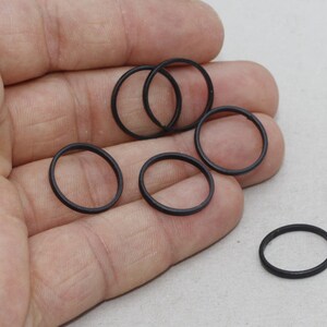 Puede incluir: Un conjunto de pequeñas juntas tóricas negras de goma. Los anillos son circulares y parecen estar hechos de un material flexible. Probablemente se utilizan para sellar o como componentes en maquinaria o equipos.