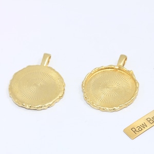 Peut inclure: Deux supports de pendentif ronds dorés avec une surface texturée et une boucle pour une chaîne. Une petite étiquette rectangulaire avec les mots "Raw Brass" est également incluse.