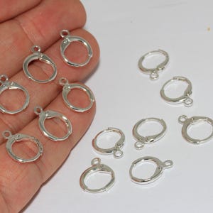 Peut inclure: Une collection de petits appr&ecirc;ts de boucles d'oreilles circulaires en m&eacute;tal argent&eacute; avec des fermoirs &agrave; levier articul&eacute;s. Chaque pi&egrave;ce pr&eacute;sente une petite boucle &agrave; la base pour attacher des breloques, avec une finition m&eacute;tallique polie.