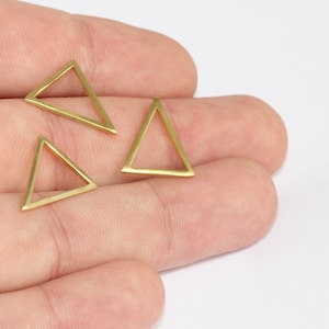 May include: Three small, open-frame triangle charms in a warm gold color. The charms are displayed against a neutral background, highlighting their geometric shape and metallic finish. These charms are suitable for jewelry making or craft projects.