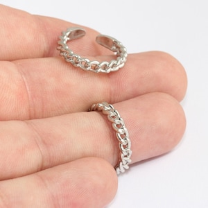 Könnte beinhalten: Zwei silberfarbene Kettenringe. Ein Ring ist offen und verstellbar. Die Ringe haben ein Kettenglied-Design. Die Ringe werden vor einem hellen Hintergrund gezeigt.